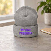 My Bad. Probably. Heather Grey beanie with purple embroidery on a softly lit desk