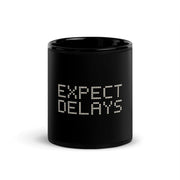Expect Delays Black Mug, centered readable front; official Printful mockup